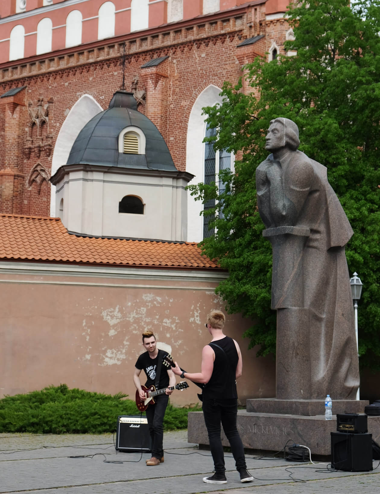 A duo rocking out in front of the statue of Adam Mickiewicz, Lithuania's national poet