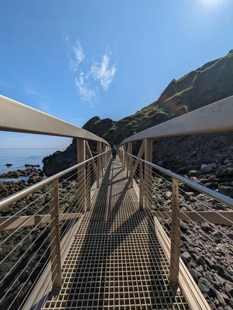 Crossing a metal pedestrian bridge on the Gobbins coastal walk