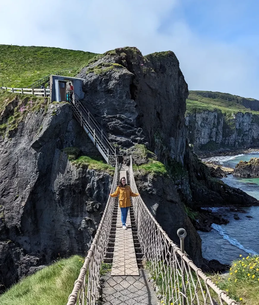 A woman in a yellow coat on the Carrick-a-Rede rope bridge