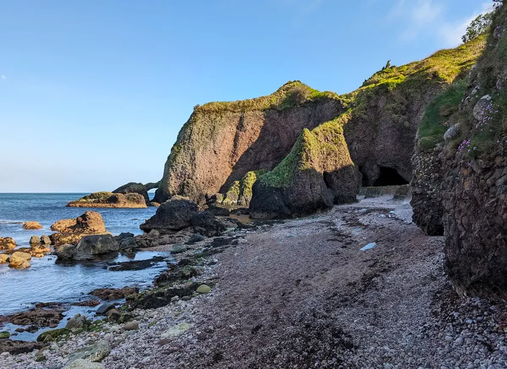 A pebbly beach with rock formations and caves