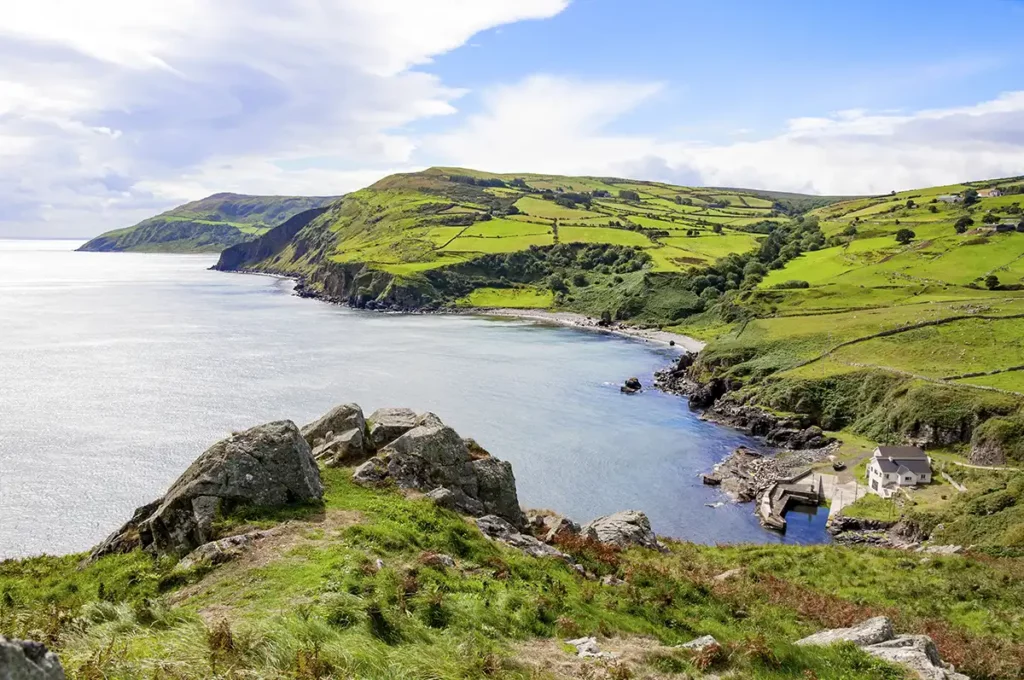 A view across a green, hilly and wild coastline