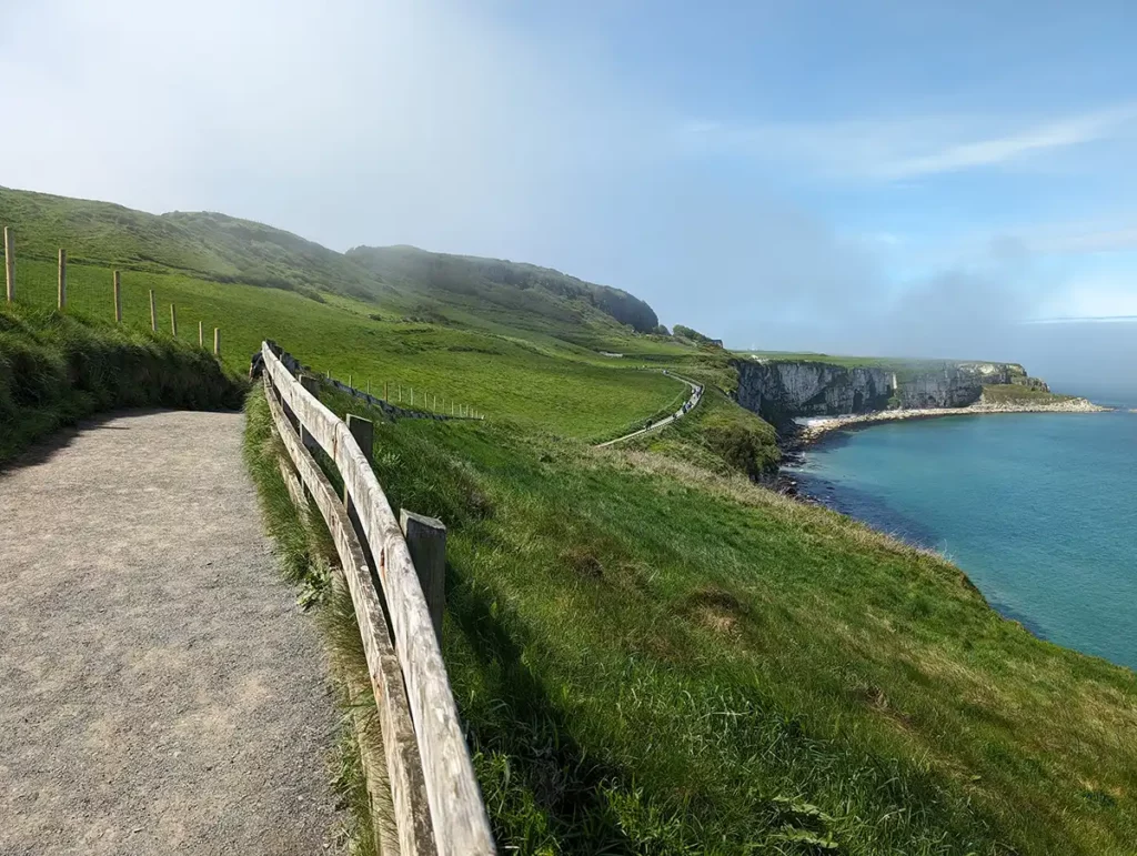 A wide gravelly path along a cliff above the sea