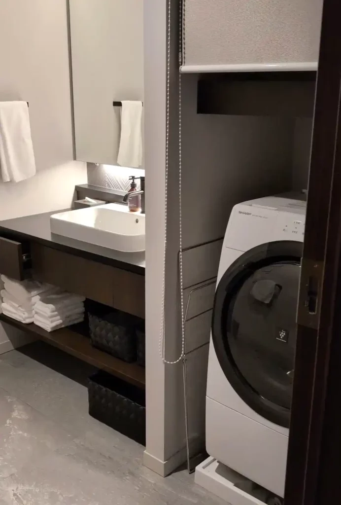 A bathroom with a washing machine and sink