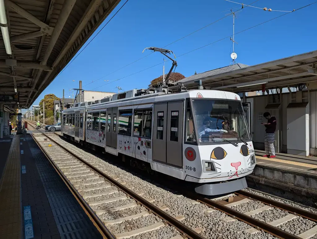 A train with a cat face on the front at a station in Tokyo