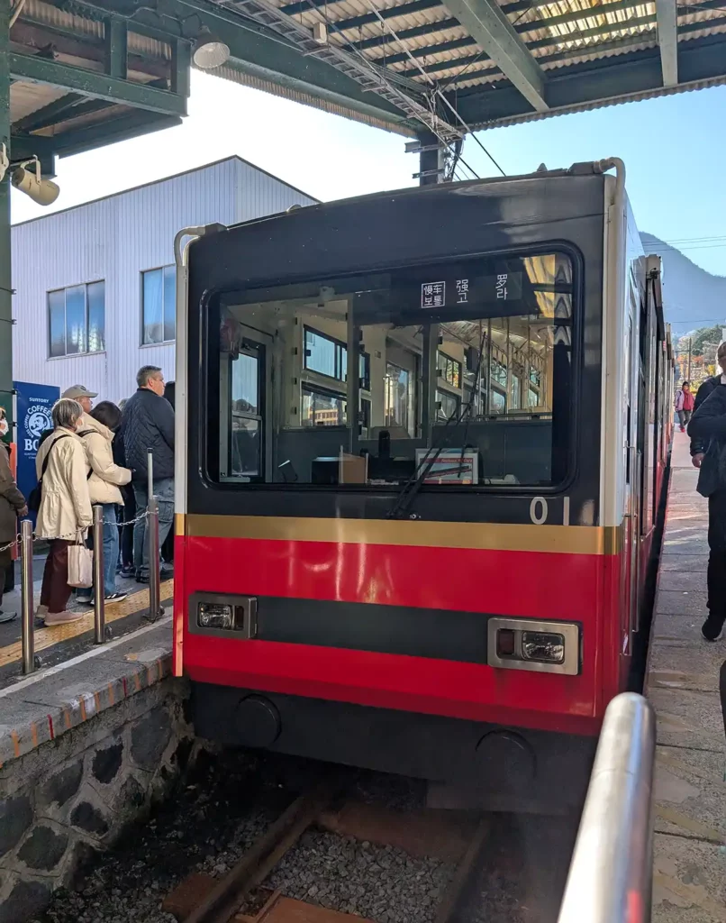 A red funicular train arriving at Gora station