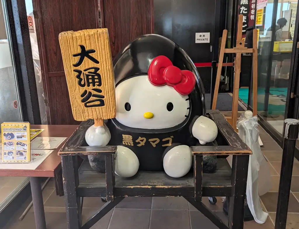 A Hello Kitty figure dressed in a black egg costume