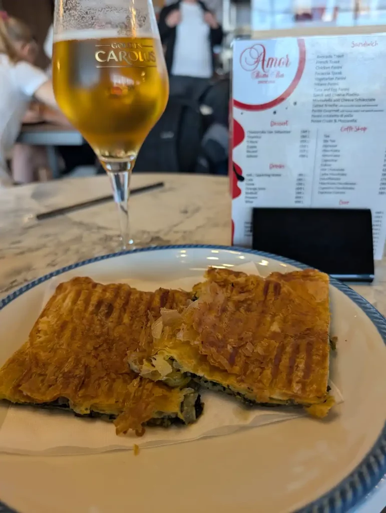 One last slice of spinach pie and a beer at Tirana Airport