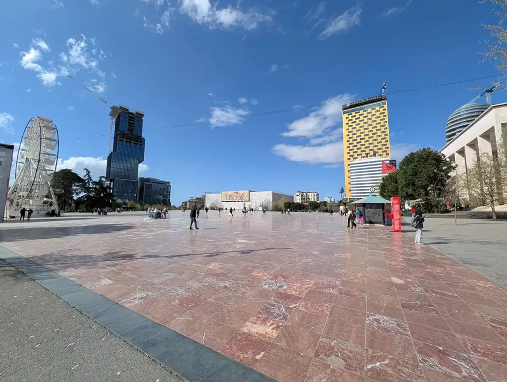 A vast, paved square, with a range of different building styles around the edges